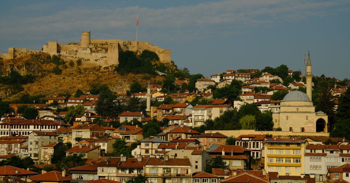 Scenic view of a Turkish town with an ancient citadel and mosque at dusk.